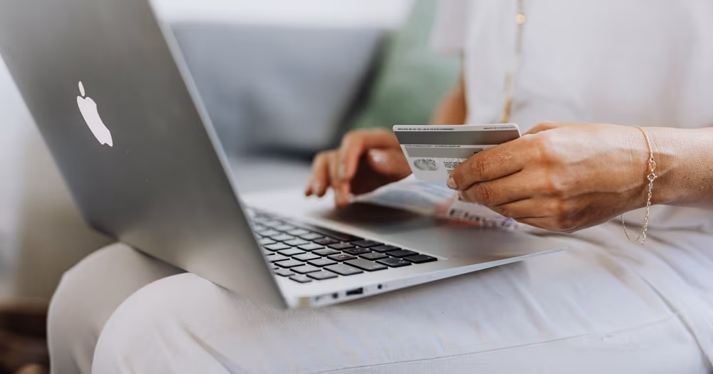 Personne utilisant sa carte bancaire sur un ordinateur portable