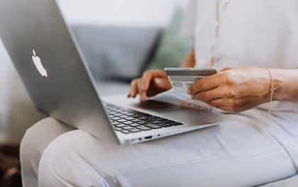 Personne utilisant sa carte bancaire sur un ordinateur portable