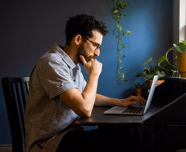 Particulier consultant ses dossiers à domicile sur son ordinateur